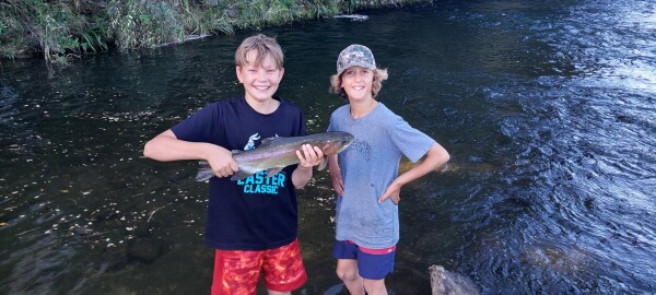 Marvin Daniel (left) holding Dougal McGregor’s (right) first ever trout caught on the Fish & Game Stone Jug Road Access property. Credit Fish & Game